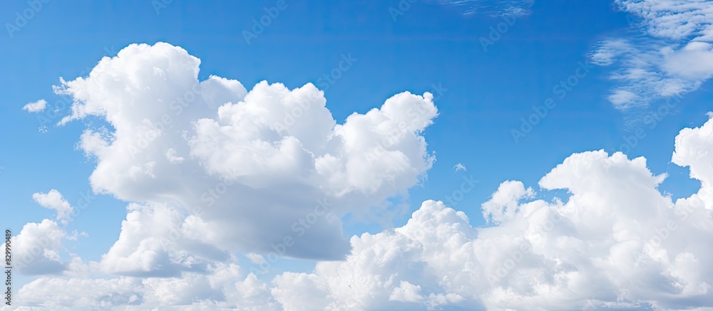 Poster a copy space image of a clear blue sky adorned with fluffy white clouds