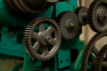 A machine with many gears, one of which is missing. The machine is green and has a metallic look