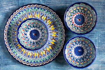 plates with intricate paintings in Asian style. On a blue background. view from above.