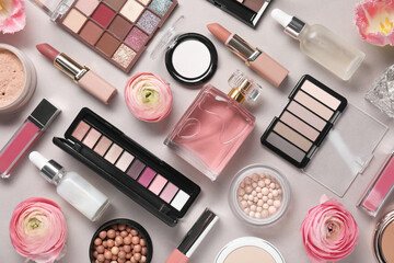 Flat lay composition with different makeup products and beautiful spring flowers on grey background