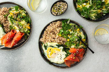 Delicious healthy breakfasts, green buckwheat with fried egg and spinach and red salmon fish, mix salad with fresh herbs and peppers and seeds, healthy balanced breakfast with fats, fiber and protein