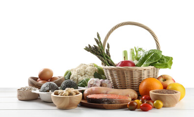 Healthy food. Basket with different fresh products on wooden table against white background