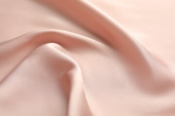 Crumpled pink silk fabric as background, closeup