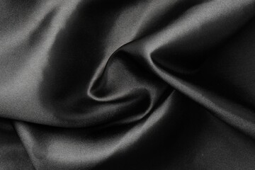 Crumpled black silk fabric as background, top view
