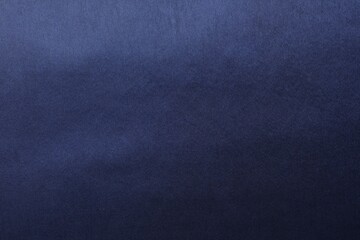 Texture of dark blue silk fabric as background, top view
