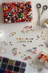 Obraz premium Making friendship bracelets with letter beads. Jewelry making supplies on the table. Flat lay.
