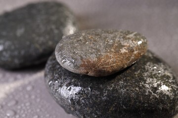 Wet spa stones on grey background, closeup
