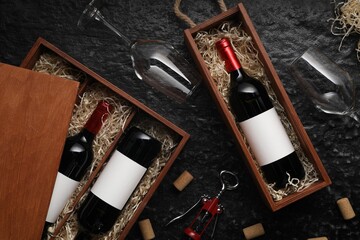Flat lay composition with bottles of wine in wooden boxes on dark textured table