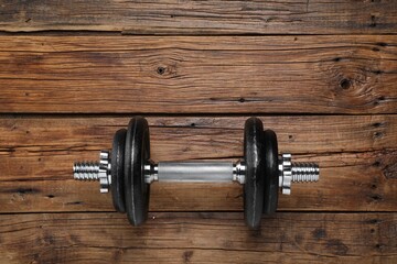 One barbell on wooden floor, top view. Space for text