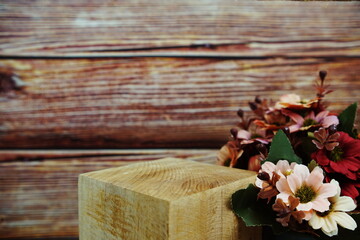 Wooden podium stand for product display with flower decoration on wooden background