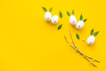 Easter background. Eggs in shape of bunnies made of spring leaves and willow bud, with willow sprigs