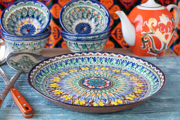plates with intricate paintings in Asian style. On a blue table.