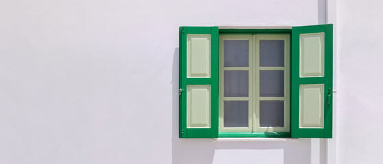 typical greek architecture, house with white exterior wall, window with white and green shutters,...