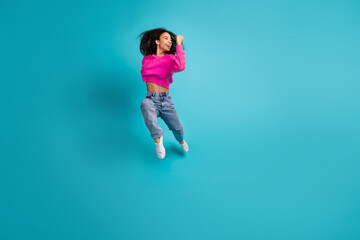Full size photo of pretty teen girl jump running wear trendy pink outfit isolated on aquamarine color background