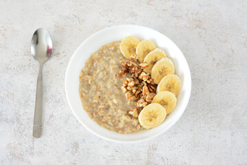 a bowl of oatmeal with banana and nuts top view