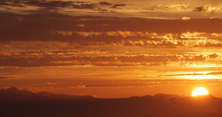 Sunset over British Columbia mountains at sea