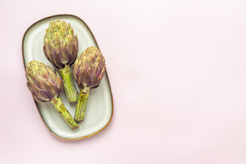 Fresh vegetables - raw artichokes. Green and purple artichoke flower buds
