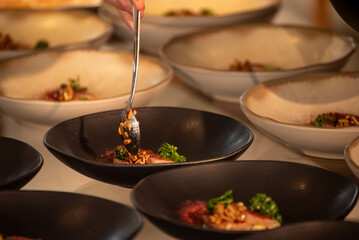 fine food beeing batch prepared on black plate