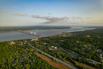 Highway Bisects a Green Forest Leading to a Bridge that Crosses a River under a Sunrise