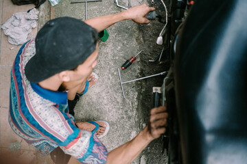 A motorcycle mechanic inspecting a damaged engine