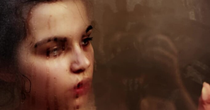 Woman touching steamy shower glass with hand closeup