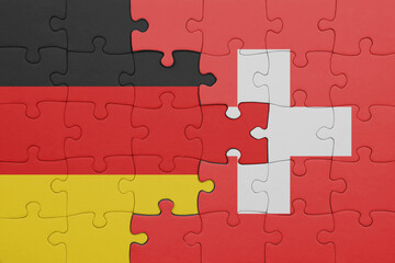 puzzle with the colourful national flag of switzerland and flag of germany.