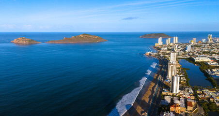 An aerial view of Mazatlán Beach on a sunny morning, showcasing the blue ocean's gentle waves...