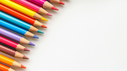 Fototapeta premium Colored pencils lie in a row on a light background close-up. Flat lay. View from above. Background with colored pencils with copy space.