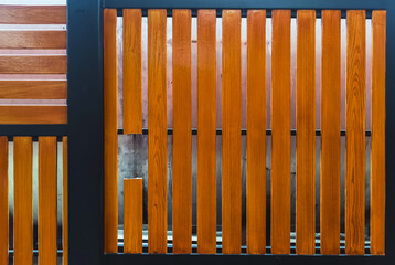 Fototapeta premium Broken shera wood board fence. Hole in wooden wall. Damaged weathered brown picket fence with broken rails and planks. A broken plank on the fence. Wooden wall with broken boards. Broken fence.