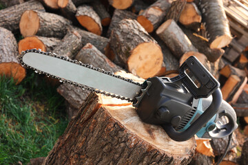 One modern saw on wooden log outdoors