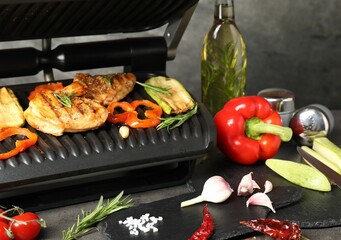 Electric grill with different products on grey textured table