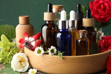 Aromatherapy. Different essential oils and flowers on table