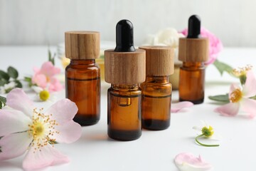 Aromatherapy. Essential oils and flowers on white table, closeup