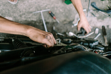 A motorcycle mechanic inspecting a damaged engine