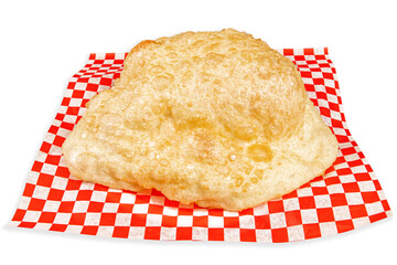 A large Indian deep fried puffed up Puri bread isolated on white