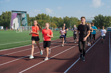 Obraz premium Group of young athletes training at the stadium. School gym trainings or athletics