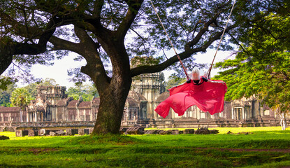 Beautiful young blond girl swing over the green fields - Acacia tree on the background of the...