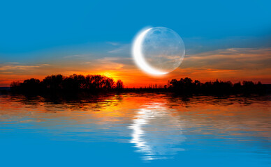 Crescent moon above the lake at amazing sunset in the background