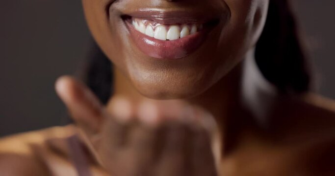 Hand, kiss and mouth with black woman flirting in studio on dark background for beauty or skincare. Blow, lips and love with smile of confident person closeup for affection, desire or romance