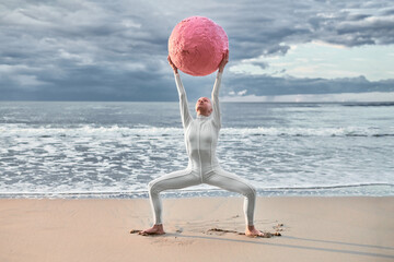Hairless performer girl with alopecia in white futuristic suit dancing with pink sphere at sea,...
