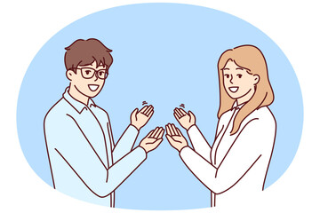 Couple of man and woman in business clothes make inviting gesture with hands. Guy and girl who created own startup are pointing back to inviting those who want to learn more about company