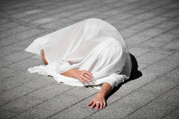 Female performer covered in white silk scarf waving gracefully, female outdoor dance performance on...