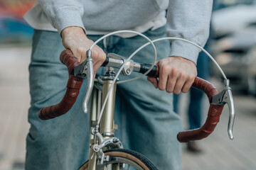 close-up of hands of young man on handlebars of vintage bicycle