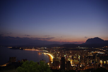 Llega la noche en Benidorm desde lo alto de la montaña, dejando ver las luces de la ciudad