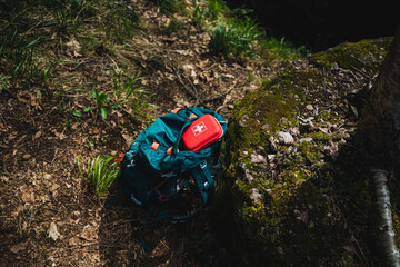 Stay safe and prepared on your outdoor hiking adventure with a Swiss first aid kit in your backpack. Essential gear for wilderness exploration on the forest floor