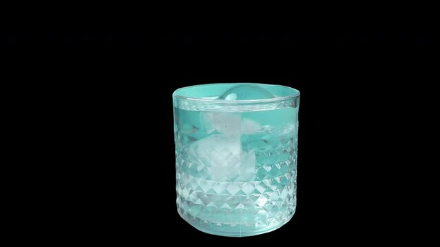 Pouring cold mineral water , crystal glass isolated on black background. 4K video.