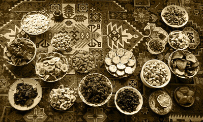 Eastern feast. Asian still life of dried fruits and nuts in plates on a carpet
