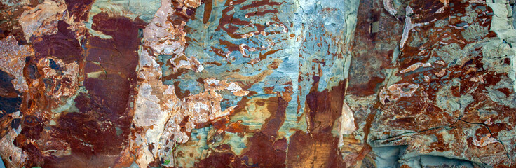 Different colors and a unique pattern on a stone a sunny day. Lines, cracks and damage of natural stone close-up. Abstract texture stones, natural patterns for design art work.