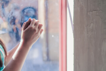 young woman clasped her hands together in prayer asking for forgiveness from God based on her...