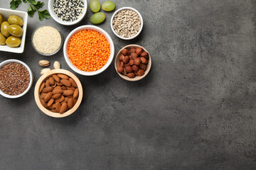 Different products high in natural fats on grey table, flat lay. Space for text